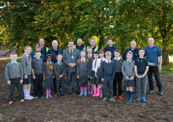 Mayor of Antrim and Newtownabbey, Councillor John Scott and pupils of Antrim and St Comgall's Primary Schools at the wildflower meadow at Antrim Forum. They are joined by Kate McAllister, RSPB, Ivor Falls, Randalstown and District Beekeepers, Mark Bryson, Ecoseeds and members of the Parks Team.
