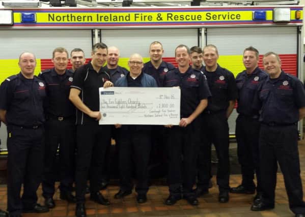 The crew from Carnlough Fire Station including Martin Campbell (front row right, holding cheque) present  Alan Knell of The Fire Fighters' Charity (front row left)with a cheque for Â£2800. INLT-50-702-con