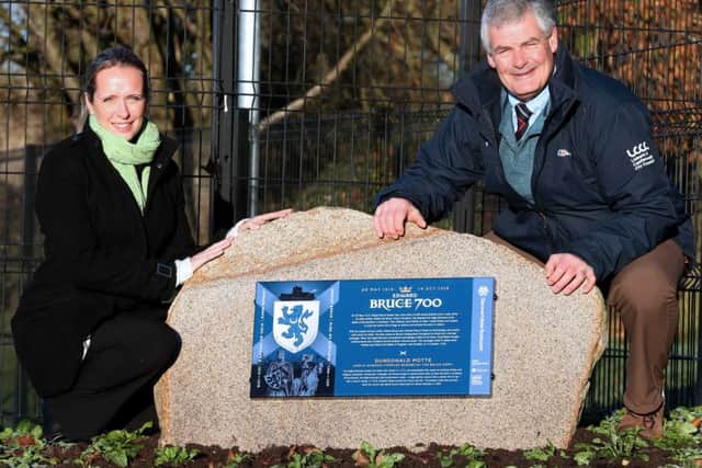 Councillor Tim Morrow, Chairman of the council's Leisure & Community Development Committee, unveils the Edward Bruce Commemorative Boulder at Moat Park with Catriona Holmes from the Ulster Scots Agency.
