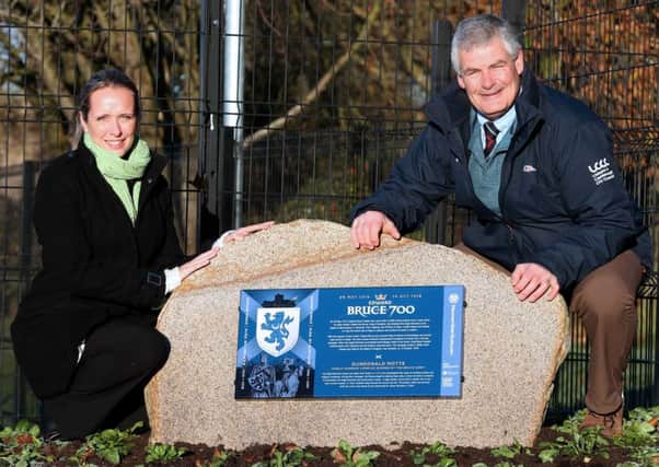 Councillor Tim Morrow, Chairman of the council's Leisure & Community Development Committee, unveils the Edward Bruce Commemorative Boulder at Moat Park with Catriona Holmes from the Ulster Scots Agency.