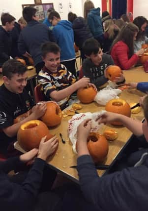 Junior boys getting stuck in to carving pumpkins
