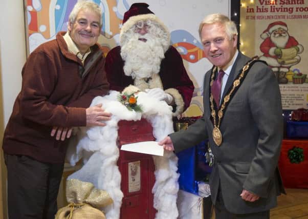 Pictured at Santa's Mailbox outside his new Grotto in the Irish Linen Centre and Lisburn Museum are  Councillor Tim Morrow, Chairman of the Council's Lesiure and Community Development Committee; Santa Claus; and the Mayor, Councillor Brian Bloomfield MBE.