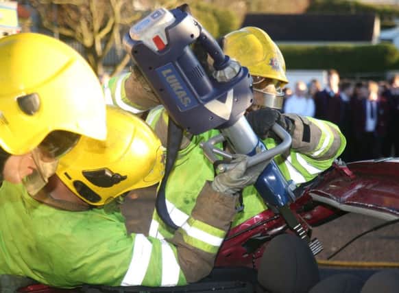Firefighters use cutting equipment during the road collision demonstration.