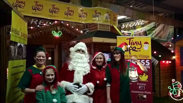Tinylife volunteers and Santa at his grotto held at Ahead in Sheds.