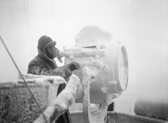 Ice forms on a 20-inch signal projector on the cruiser HMS Sheffield while she is helping to escort an Arctic convoy to Russia