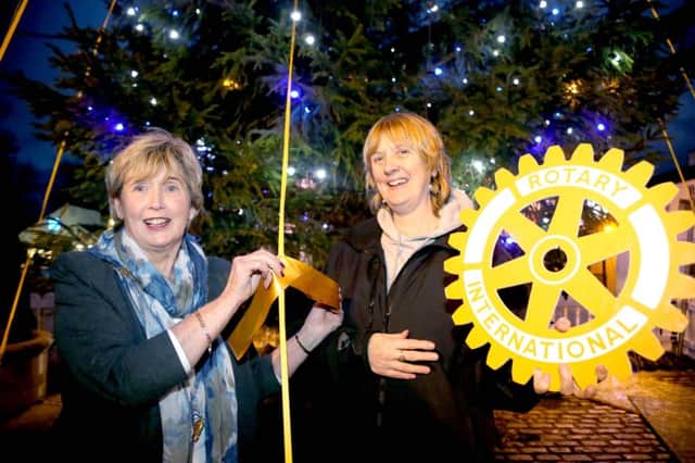 The Mayor of Causeway Coast and Glens Borough Council, Alderman Maura Hickey, pictured at the Tree of Remembrance in the Diamond in Ballycastle with Mary O'Driscoll from the town's Rotary Club as they prepare to tie yellow ribbons of remembrance onto the tree.