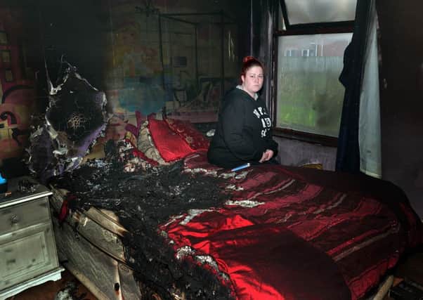 Sarah Harper surveys the fire damage to her bedroom. INLM50-206.
