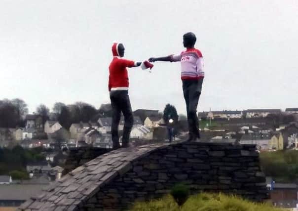 The famous figures in Maurice Harron's 'Hands Across The Divide' wearing Christmas jumpers on Wednesday. (Photo: Cormac McKenna)