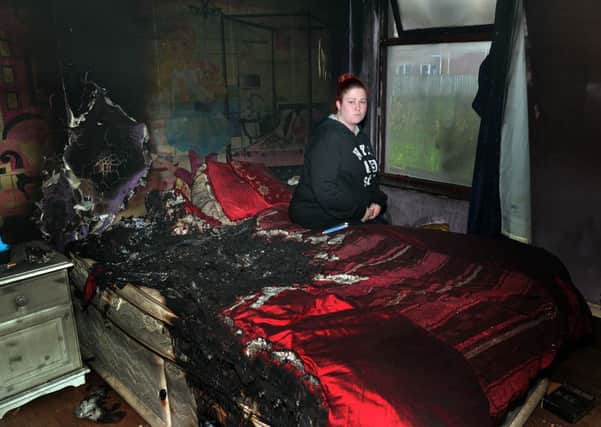 Sarah Harper surveys the fire damage to her bedroom. INLM50-206.