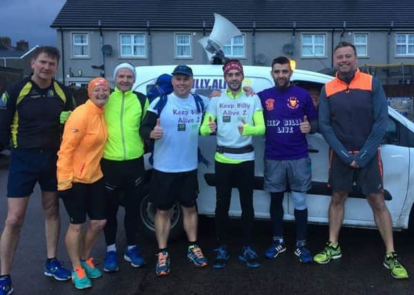 Kyle Moore (centre, with red headband) is pictured with supporters as he runs through Larne and Carrick to fundraise for his brother Billy. INLT-52-713-con
