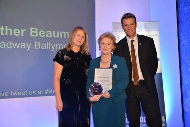 Heather Beaumont receives her Carer of the Year from double Olympic gold medallist and Headway UK Vice President James Cracknell and Erika Turner, award sponsor. INCT 51-654-CON