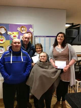 Liam presents Â£900 to Jean McGoldrick, Down Syndrome Association South Derry branch.