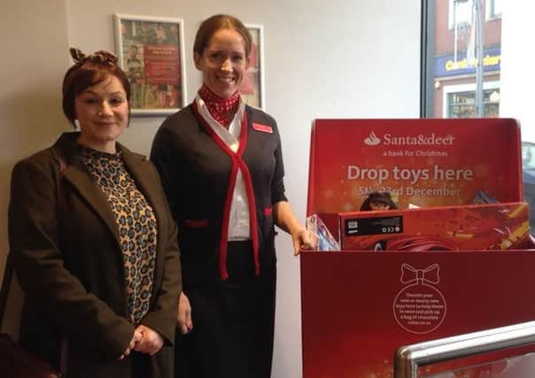 Toys donated at Santander in Larne have been presented to the Women's Aid charity. Pictured are Janine Kinnear, Santander and Paula from Women's Aid. INLT 52-650-CON