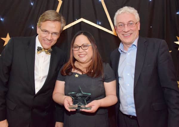 Alfie Corvera receives her award from Tim Hammond (left), Chief Executive of Four Seasons Health Care, and Mike O'Reilly, Risk Management Director.