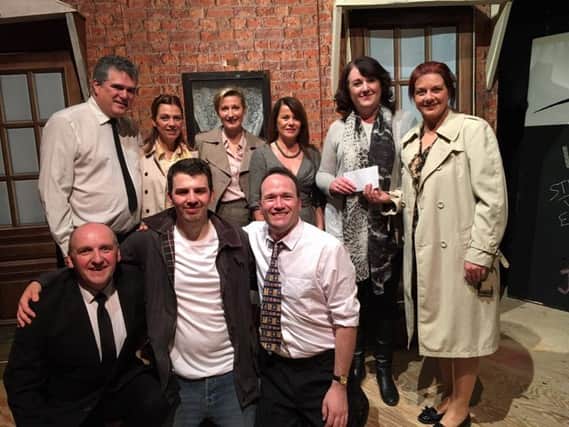 The cast of Blood Brothers hand over a cheque for Â£2337 to Women's Aid representatives Sharon Burnett and Kate Coates.