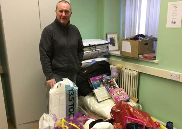 Cllr Declan McAlinden with just some of the many gifts donated to his Christmas Appeal