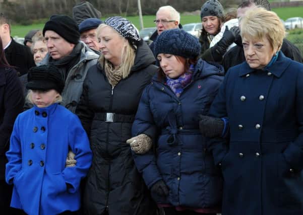 Jean Caldwell (far right) whose husband Cecil was killled at Teebane, stands arm in arm with family members at the service to mark the 20th anniversary of the atrocity.