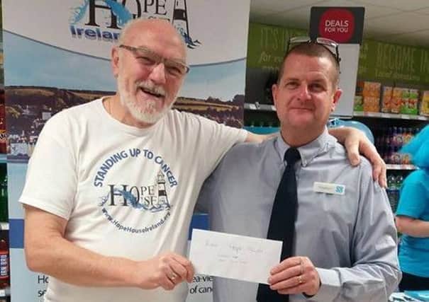 Matt Thompson, committee member, of Hope House, receives a cheque from Stephen Steele, manager, Co-Op, Larne
