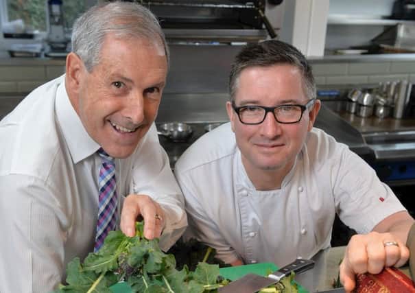 Chairman of Lisburn & Castlereagh City Council's Development Committee, Cllr Uel Mackin (left) receives a cooking lesson from Chris McGowan, Michelin star-trained chef and joint owner of Wine & Brine, Moira.