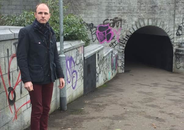 Councillor Darryn Causby beside some of the decorative  stonework that has been defaced.