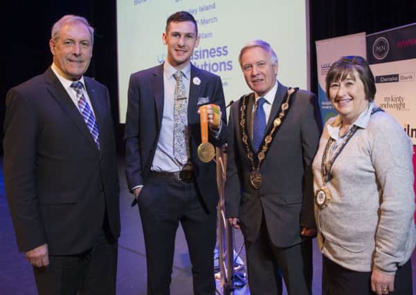 Michael McKillop shows his latest gold Paralympic medal to Councillor Uel Mackin, Chairman of the council's Development Committee, Mayor Brian Bloomfield MBE and Mayoress Mrs Rosalind Bloomfield.