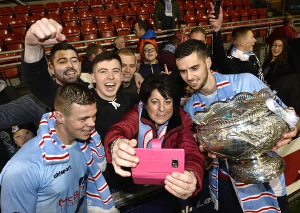 Ballymena United players Leroy Millar and Caolan Loughran pose with the League Cup trophy in front of supporters. Pic by PressEye Ltd.