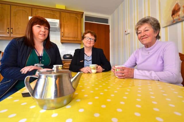 Ahoghill woman, (right) Emily Fleming, enjoys a cuppa in her new kitchen with (centre) Housing Executive Area Manager Mairead Myles Davey and (left) Housing Executive Schemes Officer, Carol OKane.