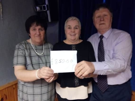Angela Chambers  from Action Cancer receives Â£850 from Lorna and Sammy Blair.