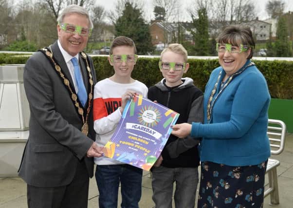 Mayor Brian Bloomfield MBE and Mayoress Mrs Rosalind Bloomfield are pictured putting on the glasses to 'Look, Act and Care' alongside two children who are currently being cared for away from home.