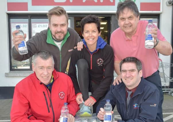 Grahame Todd (back right) pictured with Ryan Armstrong, Henderson Group (front right) and members of the Larne Half Marathon Organising Team.