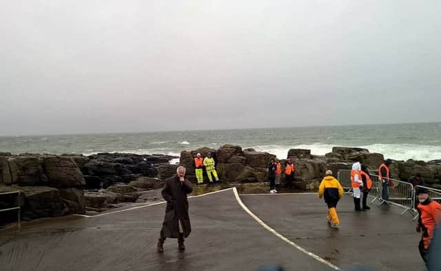 Compere Brian Moore battles on against the elements to provide commentary for a very wet RNLI fundraising Duck Dive.