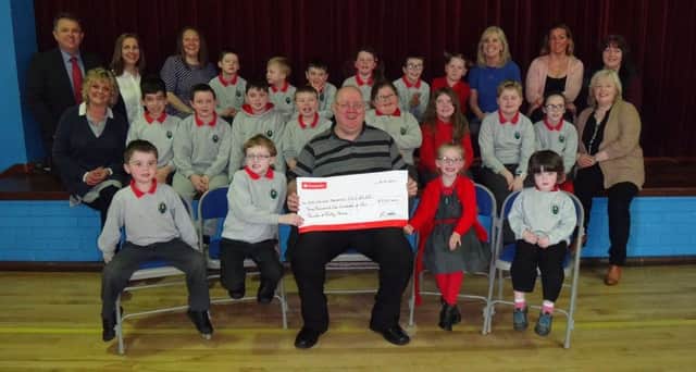 Mo Watton presents the cheque to DH Christie's Learning Support Unit staff and pupils.