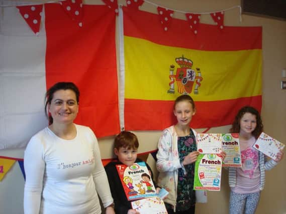 Christina McGarvey with some of her 'graduates'. These 8 to 11 years old can be seen with their Spanish Award Certificate and an introductory book to French.