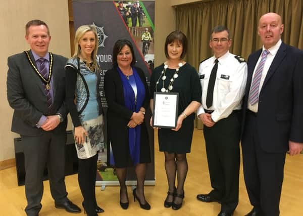 Sharon McCrum receives her recognition certificate. Pictured (l-r) are Cllr Paul Greenfield, Carla Lockhart MLA, Mrs Anne Connoly OBE (Chairperson of NI Policing Board), Mrs Sharon McCrum, Deputy Chief Constable Drew Harris and Alderman Junior McCrum.