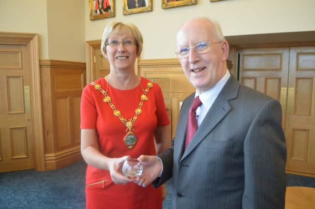 Road safety campaigner Albert Smallwoods receives a special award from the Mayor of Derry City and Strabane District Council, Alderman Hilary McClintock. INLS 14-753-CON