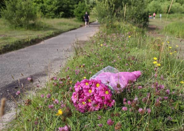 Flowers left at the spot in Colin Glen where Gary Lewis knocked down and killed Valerie Armstrong. Photograph By Declan Roughan