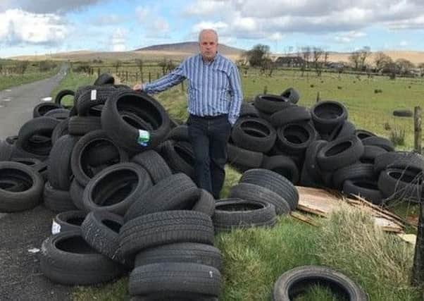 Alderman James Tinsley surveys the mess left by fly-tippers on Rushyhill Road, near Stoneyford.