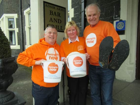 Steve Dayman, founder of Meningitis Now (right, holding walking shoes) with local supporter Sylvia Dunlop of Ballymena and the charity's Northern Ireland Community Ambassader Carl Monteith.