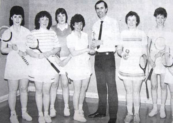 Derek Brown. leisure centre superintendent, presents the winners trophy in the Brownlow Racquets Club ladies' tournament to Mary Graham. Included are runners up Maura Teggart, Patricia Devlin, Sharon Muir, Colin McMinn, Pamela Johnston and Julia Kelley