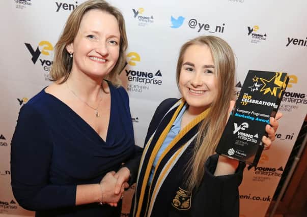 Company member from TRI-Buy from Larne High School accepts the Marketing award for the North East Area from Carol Fitzsimons MBE, Chief Executive Young Enterprise.