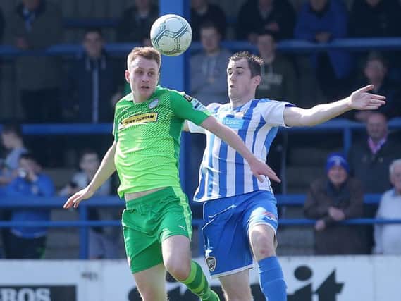 Coleraine's David Ogilby challenges Cliftonville's Aaron Haire.