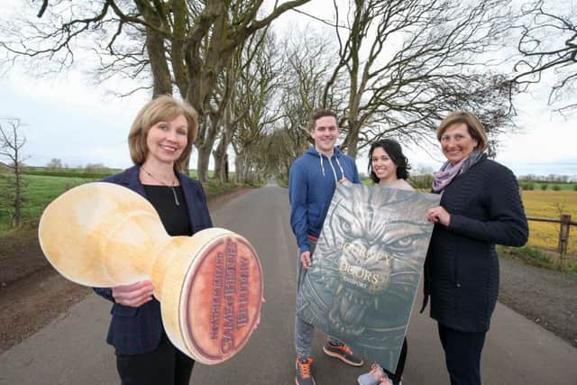 Judith Webb, Tourism NI gives international visitors Stephen Feeney and Melly Corzo from Chicago, Illinois the first stamp on their Journey of Doors souvenir passport alongside Clair Balmer, Tourism Ireland at the Dark Hedges. Tourism NI has launched a Journey of Doors passport that allows  Game of ThronesÂ® fans to visit the 10 Game of Thrones Doors across Northern Ireland and collect a unique stamp at each of the locations.