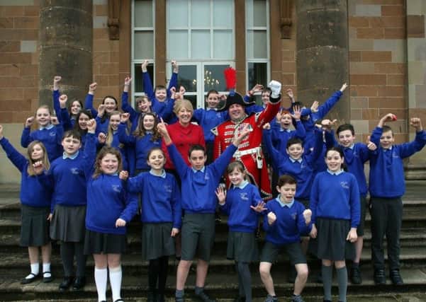 Pupils from Downshire Primary School, Hillsborough, join Patricia Corbett, Head of Hillsborough Castle and Andrew Carlisle, Bugler of the Hillsborough Guard, to celebrate news of the Heritage Lottery Fund grant for the major project at Hillsborough Castle. (Photographer: Rory Moore)