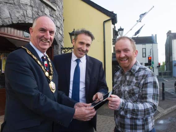 Chair of Mid Ulster District Council tests out the free WiFi now available in Maghera with Kieran Bradley and Neil Hyndman from Maghera Traders Association