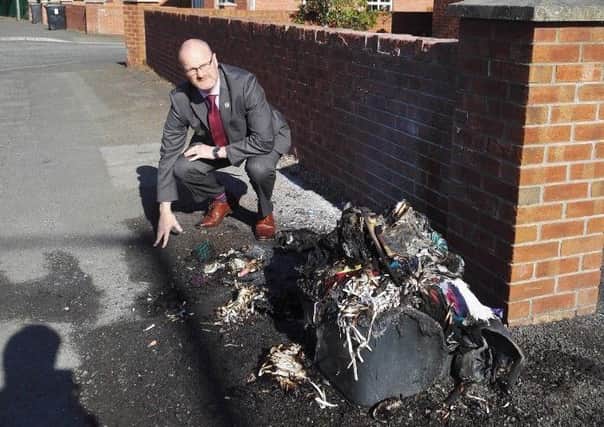 UUP Councillor Tim Mitchell assesses the damage caused after a number of bins were destroyed by arsonists in the Causeway End Road area of Lisburn.