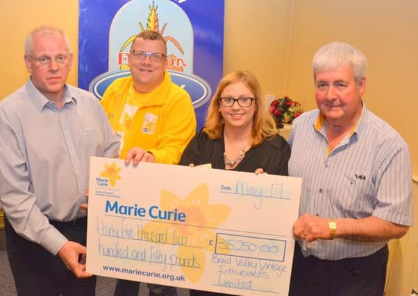 John Crothers, chairman of Braid Valley Vintage Enthusiasts Ltd, left, and treasurer Sammy Millar, right, present a cheque for Â£35,250 to Heather Miller and Colin Ferguson from Marie Curie. The funds were raised at the Big 100 tractor event. Picture: Chris McCullough.