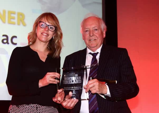 Laura Montgomery, Senior Marketing and Insight Director at Almac receives the Made in Northern Ireland Award from Bob Barbour, Director and Chief Executive of category sponsors the NI Centre for Competitiveness.
