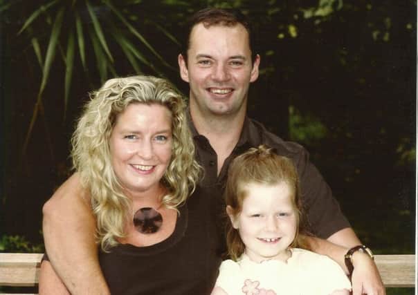 Karyn Wilson with her husband Damian and daughter Danielle. This family portrait, taken around 10 years ago, hangs in the Wilson's front room.