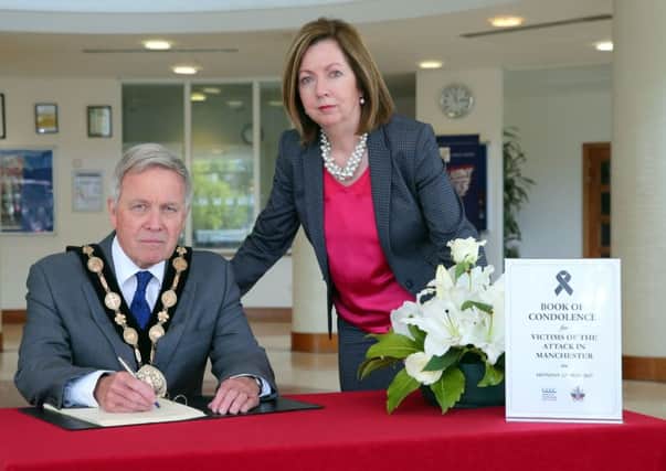Mayor Brian Bloomfield MBE signing the book of condolence at Lagan Valley Island, Lisburn for the victims of the terror attack in Manchester. He's pictured with council Chief Executive Dr Theresa Donaldson.