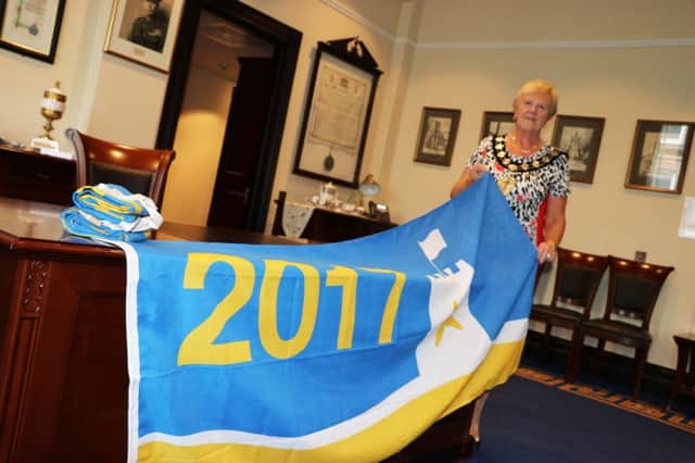 The Mayor of Mid and East Antrim, Councillor Audrey Wales MBE, with flags awarded to three beaches in the borough. INCT 21-756-CON